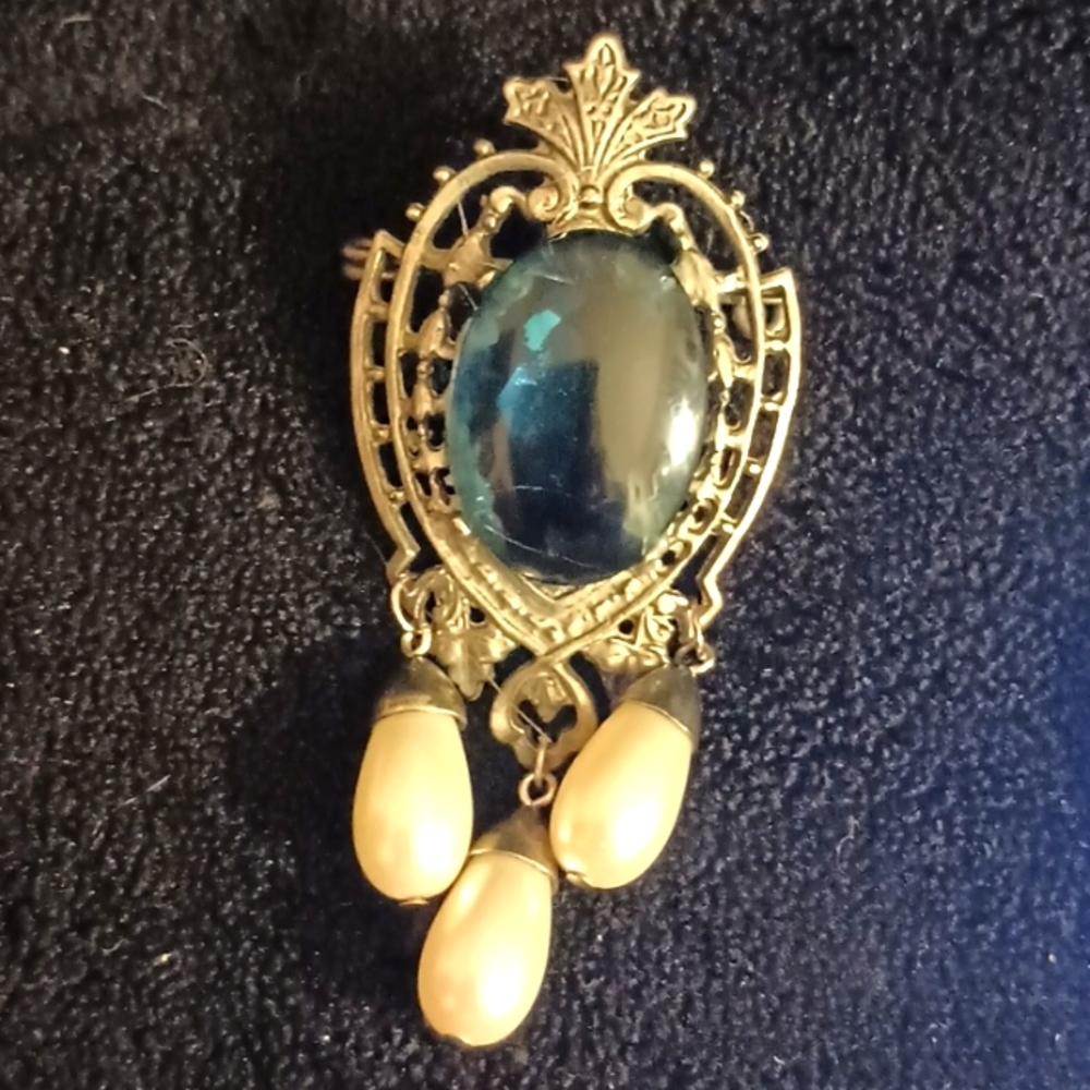 Vintage crest shaped brooch with blue stone center